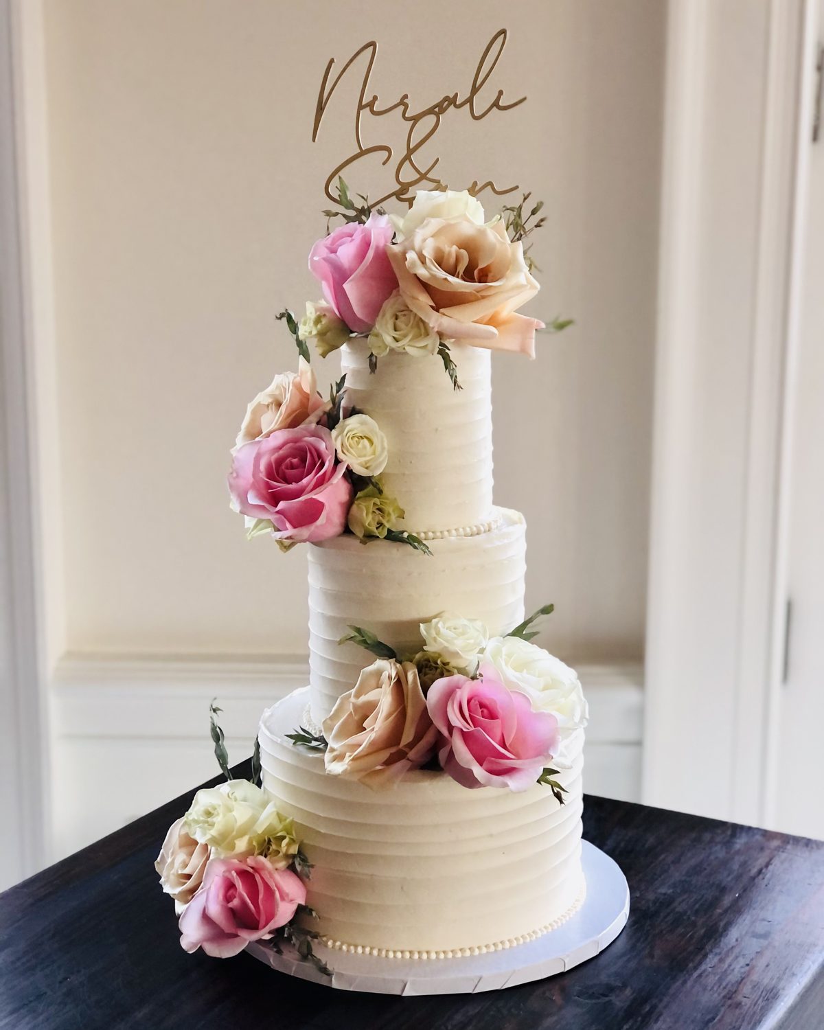 Three-tier textured buttercream wedding cake with fresh roses